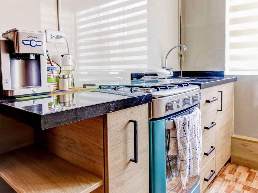 Una cocina moderna con estufa integrada, cafetera y armarios de madera.