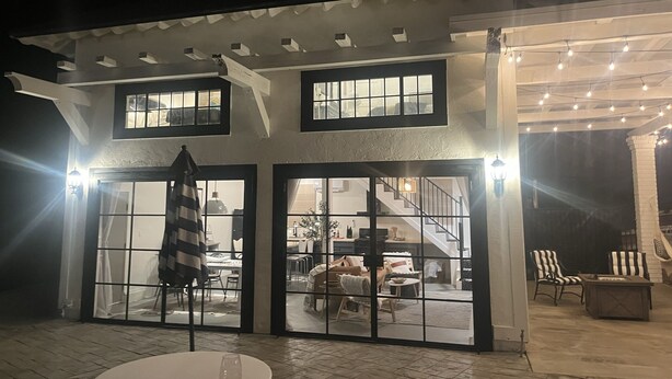 Een gebouw met twee verdiepingen en een overdekt terras.