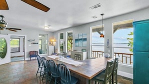 A spacious kitchen with a large island, dining chairs, and a view of the outdoors.