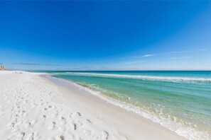 Uma praia com areia branca e águas azul-claras.