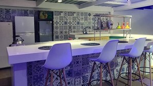 Une cuisine moderne dotée d’un îlot central, de tabourets de bar et d’un crédence décorée de motifs.