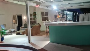 Un espace de vie moderne comprenant un îlot de cuisine, un coin repas et une piscine.