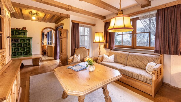 A cozy room with a wooden sofa, a wooden table, and a green cabinet.