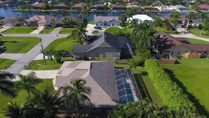 Zona residencial amb cases, una piscina i una massa d'aigua al fons.
