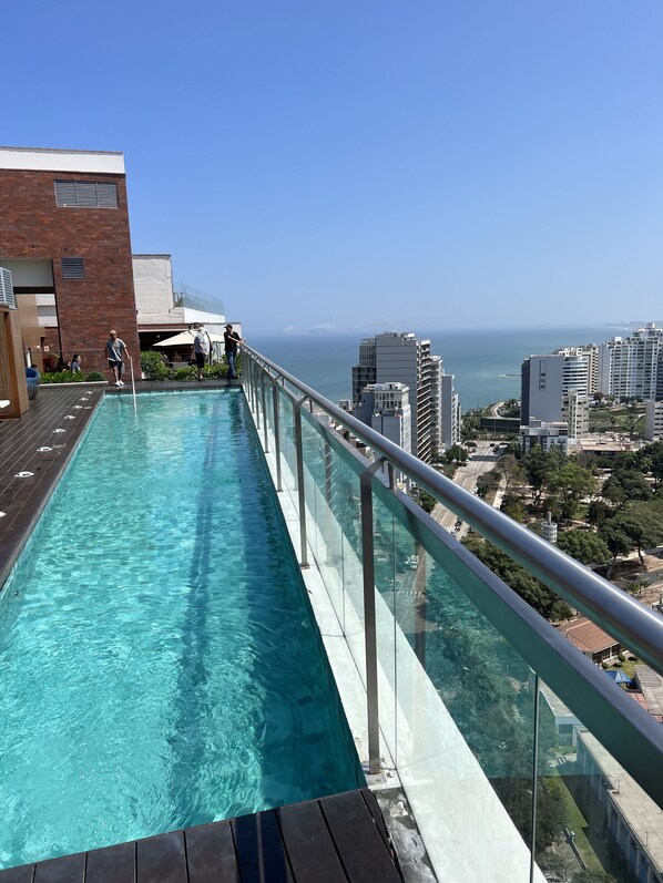 A rooftop pool with a glass railing, overlooking a cityscape and the ocean. - Ocean view! Good location, ideal for couples or small families (Barranco)