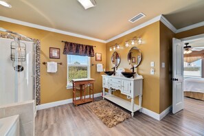 A bathroom with a shower, vanity, and a window. - Seaclusion (Gulf Shores)