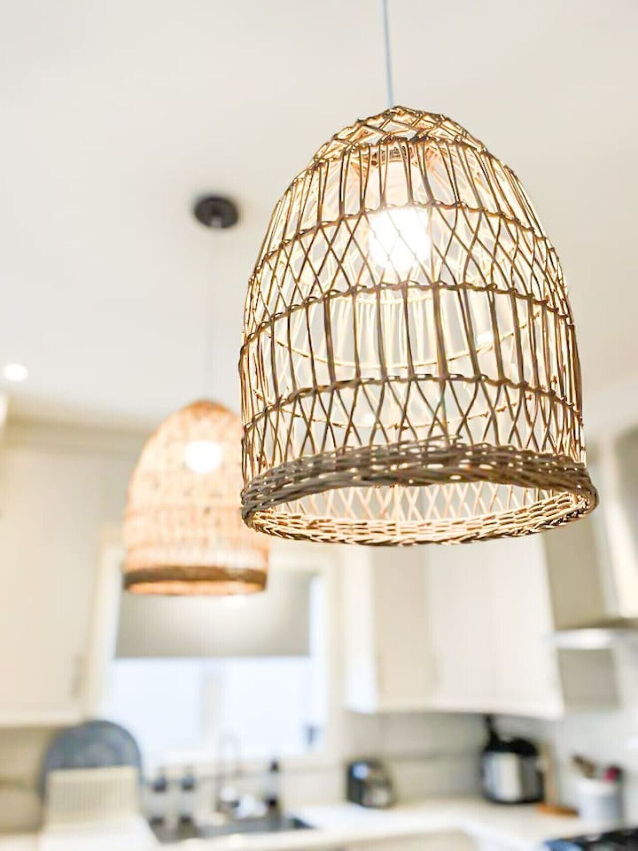 A kitchen with pendant lights hanging from the ceiling.