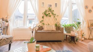 Un salon chaleureux avec un canapé, une table basse et diverses plantes.