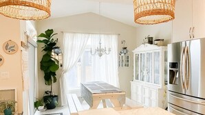 Une cuisine dotée d’un plan de travail en marbre, de meubles blancs et d’un grand réfrigérateur.