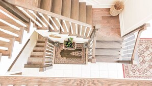 Un escalier en bois avec un tapis au bas du palier.