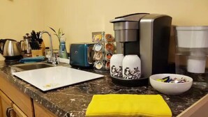 A kitchen with a sink, coffee maker, toaster, and a bowl of fruit. - Private Charming Garden Guest Suite Presidio Hts. (San Francisco)