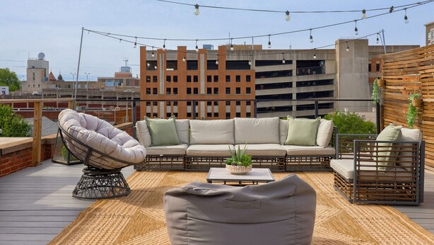 A rooftop terrace with a sofa set, a chair, and a coffee table. - Central Luxury 3-Level Home - Rooftop + Garage (Lancaster)