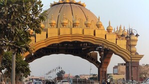 An arched structure with ornate golden domes and pillars, likely a historical or cultural landmark. - Hotel Bhullar (Amritsar)