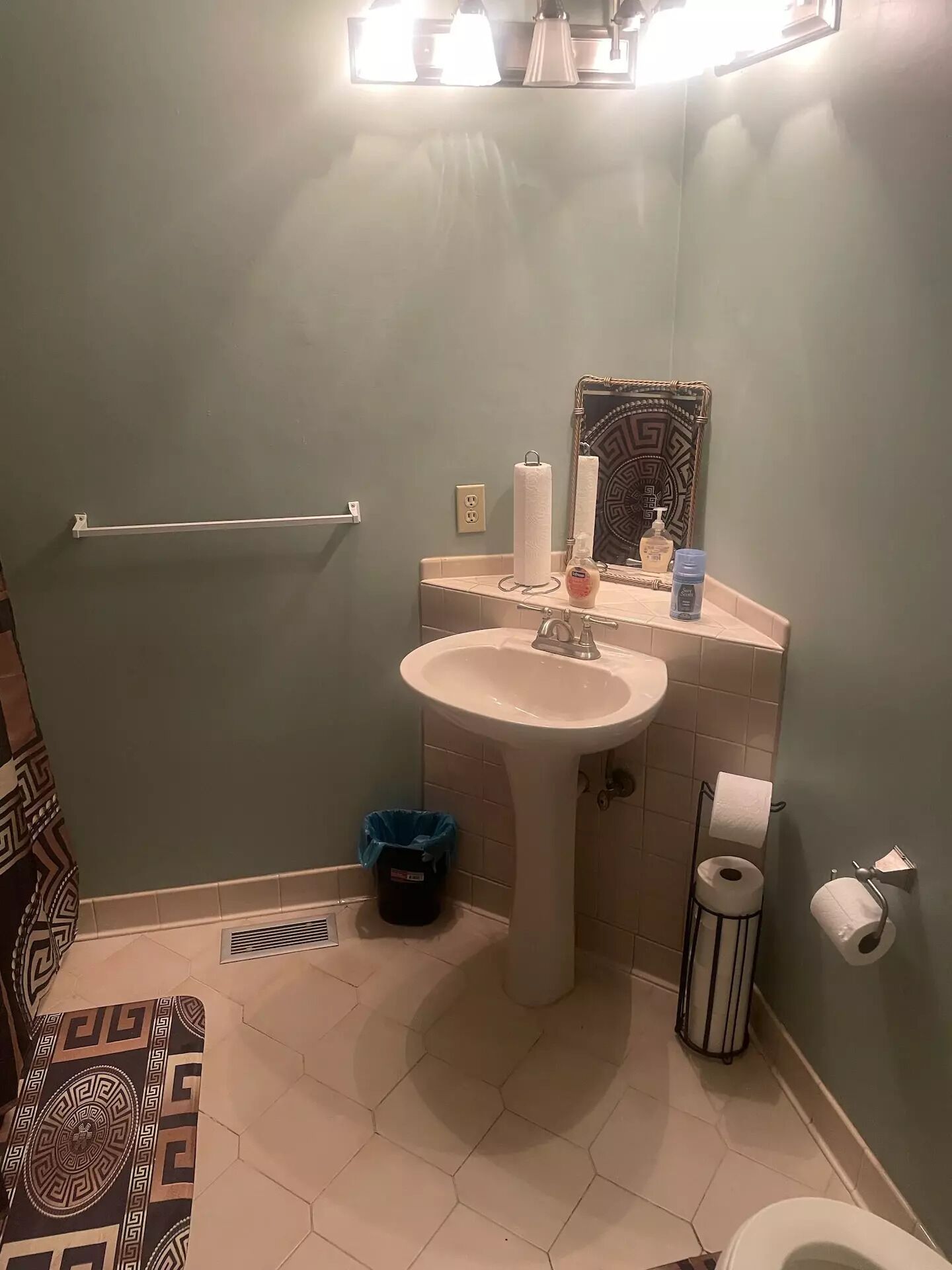 A bathroom with a sink, toilet, and a towel rack.