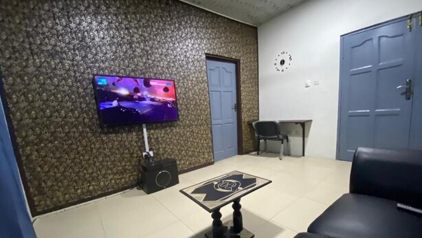 Una sala de estar con televisión, mesa de centro y sofá.