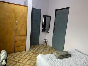 A bedroom with a bed, a wardrobe, and two doors. - O'lleaf Suite (entire first floor exclusive) (Accra)