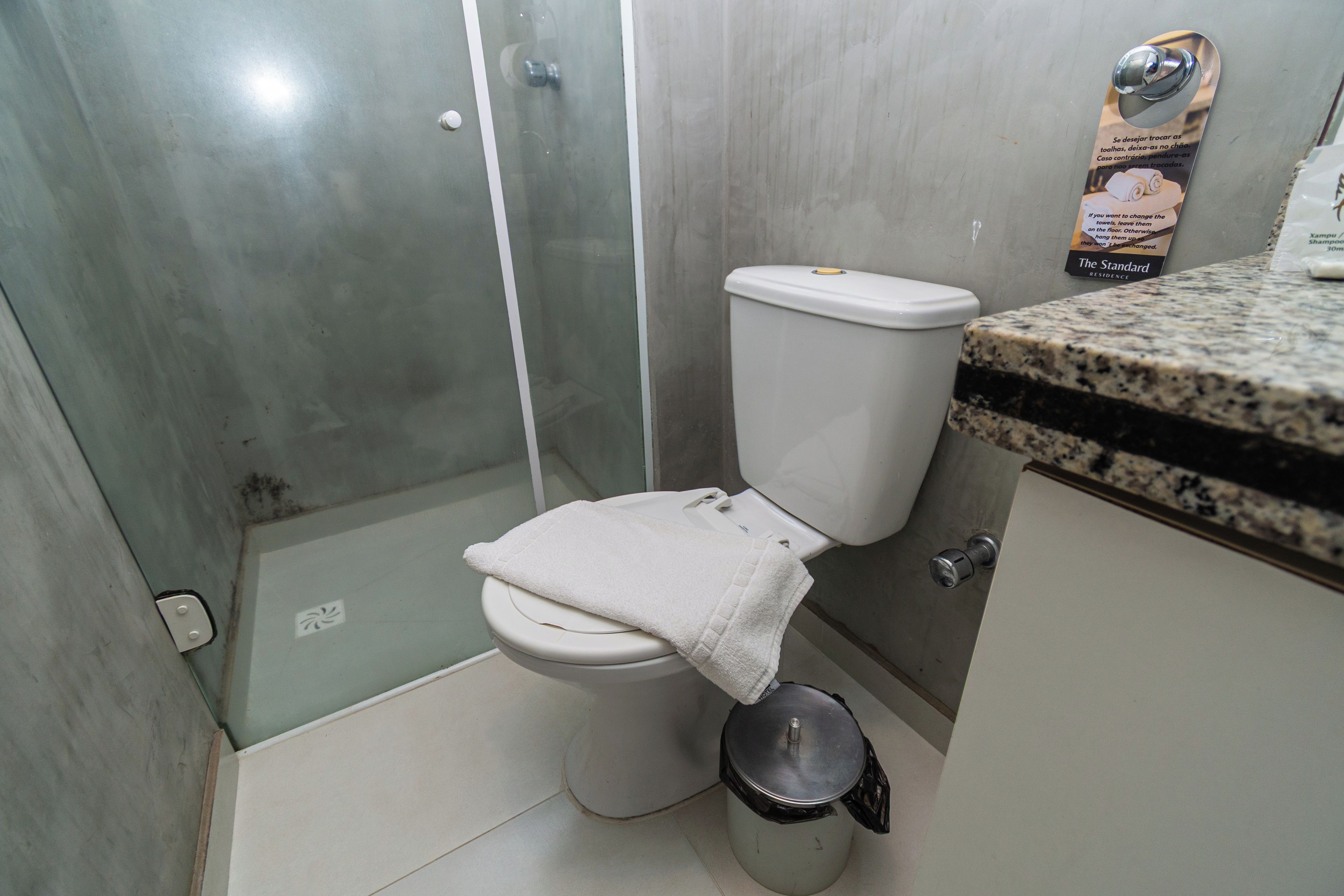 Et badeværelse med toilet, bruser og håndvask.