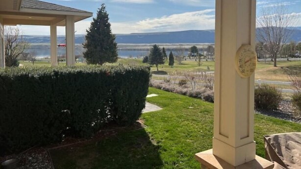 Une terrasse couverte offrant une vue sur un lac et des montagnes.