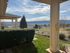 A covered patio with a view of a lake and mountains. - A20-Golf Course River View Unit Sunserra near pool Gorge shuttle book separately (Quincy)