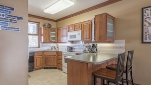 Una cucina con mobili in legno, un forno a microonde, un piano cottura e una macchina da caffè.