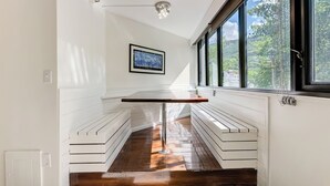 Una cocina moderna con una isla central, armarios blancos y un ventanal con vistas al exterior.
