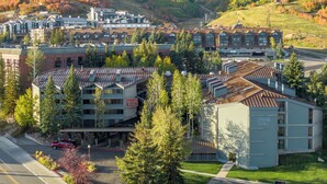 Un hotel de estilo arquitectónico moderno, con un llamativo letrero 'Silver King', rodeado de exuberante vegetación y un paisaje montañoso.