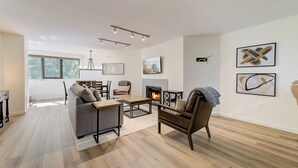 Una sala moderna con chimenea, un sofá, una mesa de centro y un comedor.