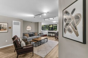 A modern living room with a sofa, coffee table, and artwork.
