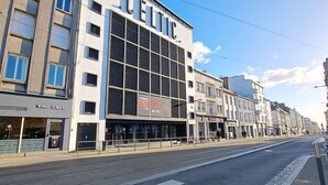 A street view with a building labeled "CELTIC" featuring a modern facade with large windows and a signboard. - Studio Calme Brest Hyper Centre (Brest)