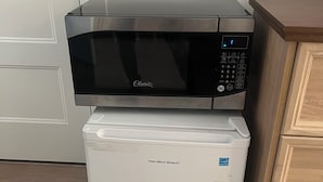 Une cuisine compacte équipée d’un four à micro-ondes et d’un mini-réfrigérateur.