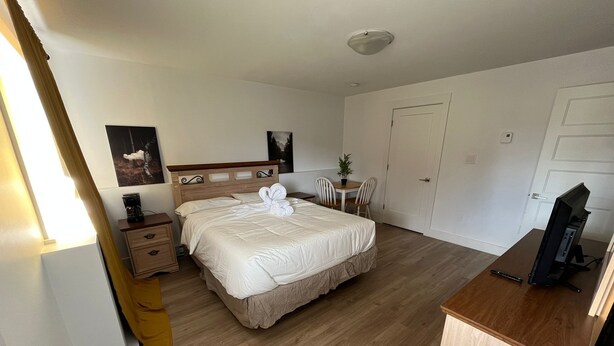 Une chambre bien rangée, avec un lit, des tables de chevet, un bureau et une chaise.