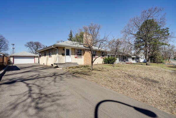 A residential house with a garage, a front yard, and a driveway. - Inviting Minneapolis Vacation Rental w/ Game Room! (Minneapolis)