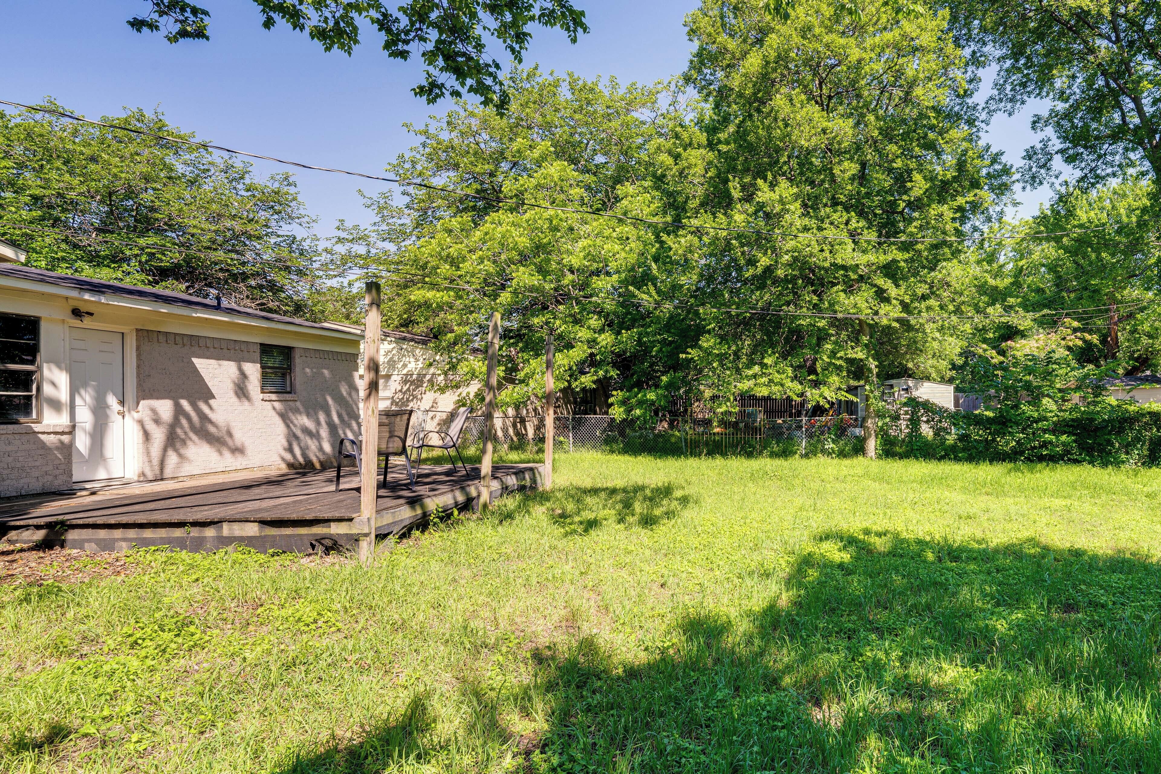 A residential property with a detached house, a wooden deck, and a grassy yard.