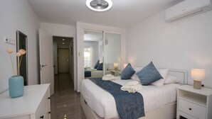 Une chambre moderne avec un grand lit, des tables de chevet, une armoire et un miroir.