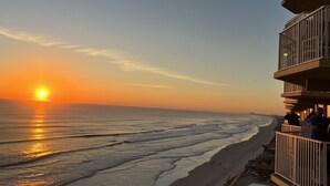 Een strandhotel met een balkon met uitzicht op de oceaan.