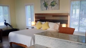 A hotel room with a bed, a desk, and a kitchenette.
