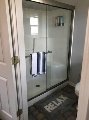 Chuveiro, toalhas de banho, papel higiênico 
