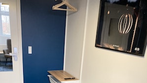 Et moderne soveværelse med en seng, et skrivebord og en hængende lampe.