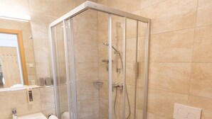 Un bagno moderno con doccia vetrata, lavandino e WC.