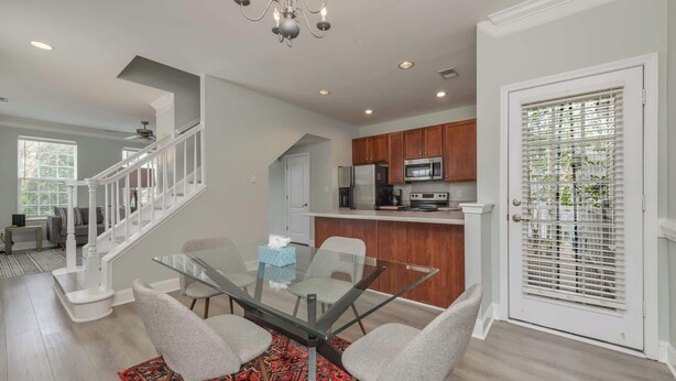 A modern kitchen with wooden cabinets, a stainless steel refrigerator, and a microwave. - Prime Downtown Cornelius Townhome (Cornelius)