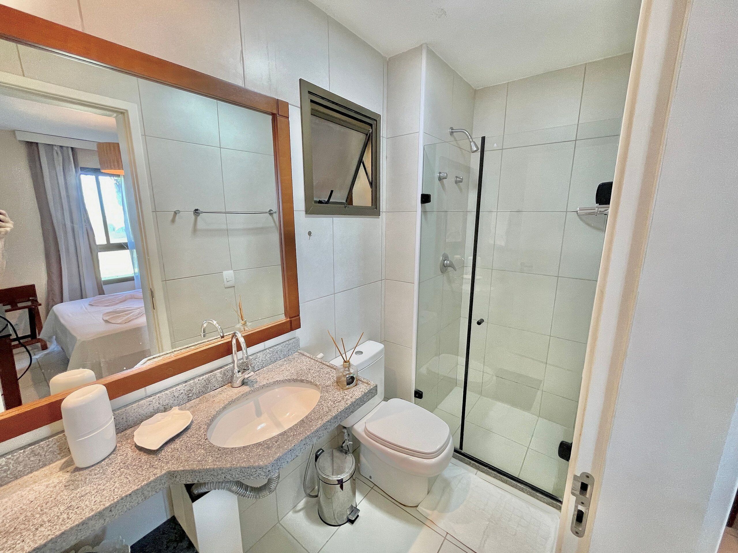 A bathroom with a sink, toilet, and glass shower enclosure.