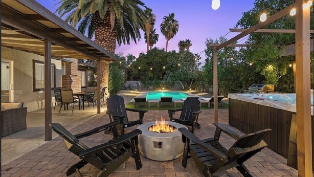 An outdoor patio with a fire pit, seating, a pool, and a bar area. - Las Vegas Oasis with Private Pool and Hot Tub 12-min from The Strip (Las Vegas)
