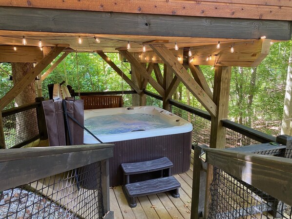 A hot tub on a wooden deck with a wooden railing and string lights. - Rustic Treehouse Oasis in Hocking Hills --Adventure Awaits (Logan)