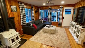 Una sala de estar acogedora con chimenea, un sofá, un tapete estampado y un televisor.