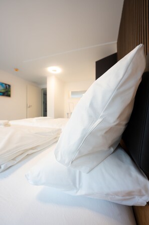 A hotel room with a bed, pillows, a headboard, and a painting on the wall. - Hostel Mannheim (Mannheim)