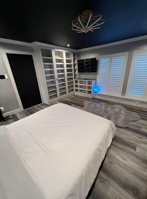 Relax in this spacious bedroom with a large bed, wardrobe, and flat-screen TV.