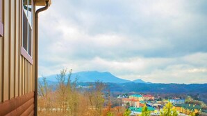 A view from a window overlooking a town with buildings and mountains in the distance.
