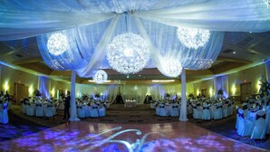 A ballroom with white draped ceilings, chandeliers, and tables set for a formal event. - Reading Vitality Hotel (Wyomissing)