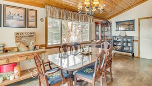 A wooden dining area with a glass table, wooden chairs, a chandelier, and a 'Welcome to our home' sign. - Fire Pit & Games! 10-Acre 'Majestic Mountain Home' (Thayne)