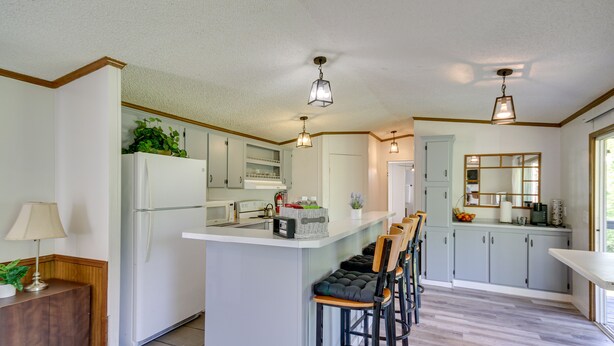 A modern kitchen with a central island, bar stools, and a refrigerator. - Fire Pit + Deck: Peaceful Silver Creek Retreat (Silver Creek)